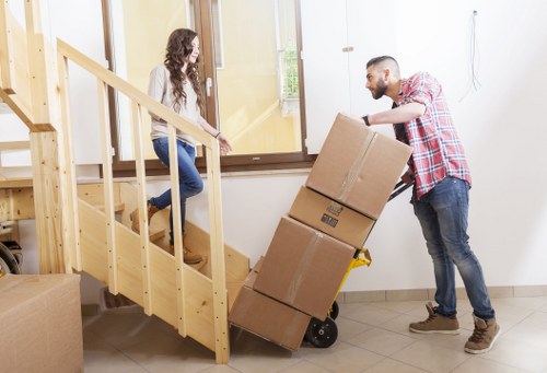 Movers handling furniture through a narrow stairwell in a Riddlesdown flat